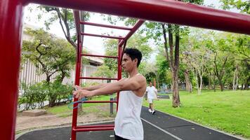 Asian man practicing gymnastics doing gymnastics bar and hoop exercises and stretching and resting for sports. video