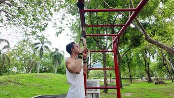 Asian man practicing gymnastics doing gymnastics bar and hoop exercises and stretching and resting for sports. video