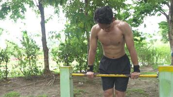 Asian man practicing gymnastics doing gymnastics bar and hoop exercises and stretching and resting for sports. video