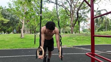 Asian man practicing gymnastics doing gymnastics bar and hoop exercises and stretching and resting for sports. video