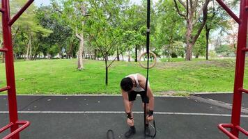 asiatisk man praktiserande gymnastik håller på med gymnastik bar och ring övningar och stretching och vilar för sporter. video