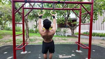 Asian man practicing gymnastics doing gymnastics bar and hoop exercises and stretching and resting for sports. video