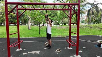 Asian man practicing gymnastics doing gymnastics bar and hoop exercises and stretching and resting for sports. video