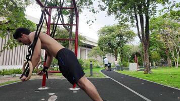 Asian man practicing gymnastics doing gymnastics bar and hoop exercises and stretching and resting for sports. video