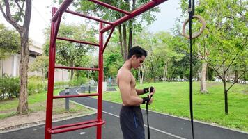 Asian man practicing gymnastics doing gymnastics bar and hoop exercises and stretching and resting for sports. video