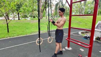 Asian man practicing gymnastics doing gymnastics bar and hoop exercises and stretching and resting for sports. video