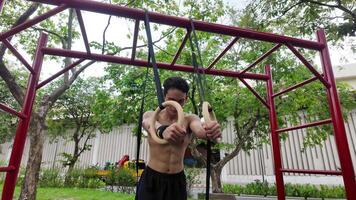 asiático hombre practicando gimnasia haciendo gimnasia bar y aro ejercicios y extensión y descansando para Deportes. video