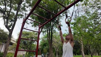 Asian man practicing gymnastics doing gymnastics bar and hoop exercises and stretching and resting for sports. video