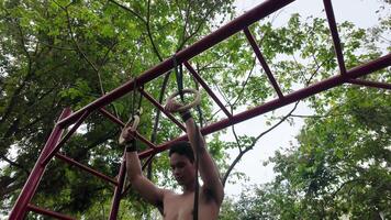 Asian man practicing gymnastics doing gymnastics bar and hoop exercises and stretching and resting for sports. video