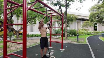 Asian man practicing gymnastics doing gymnastics bar and hoop exercises and stretching and resting for sports. video