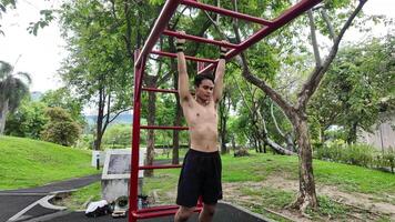 Asian man practicing gymnastics doing gymnastics bar and hoop exercises and stretching and resting for sports. video