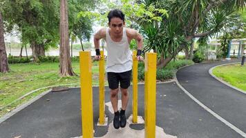 Asian man practicing gymnastics doing gymnastics bar and hoop exercises and stretching and resting for sports. video