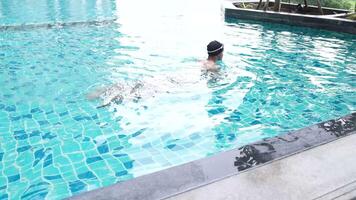 Aziatisch mannen beoefenen zwemmen en voorbereidingen treffen naar Speel water polo en uitrekken en resting voor water sport. video