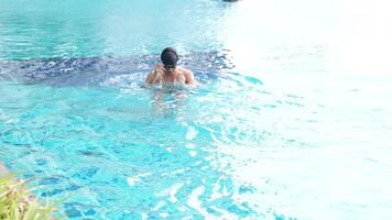 asiatisch Männer üben Schwimmen und vorbereiten zu abspielen Wasser Polo und Dehnen und ruhen zum Wasser Sport. video