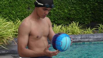asiatisk män praktiserande simning och framställning till spela vatten polo och stretching och vilar för vatten sporter. video