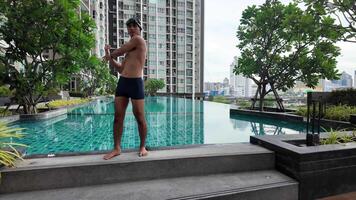 Aziatisch mannen beoefenen zwemmen en voorbereidingen treffen naar Speel water polo en uitrekken en resting voor water sport. video