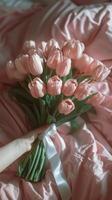 Pink Tulip Bouquet on White Bed Sheets in a Bedroom photo