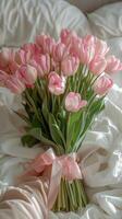 Pink Tulip Bouquet on White Bed Sheets in a Bedroom photo