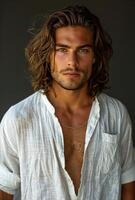 Portrait of a Young Man With Long Wavy Brown Hair and a White Button-Down Shirt photo