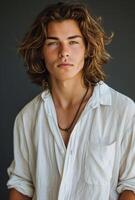 Portrait of a Young Man With Long Wavy Brown Hair and a White Button-Down Shirt photo