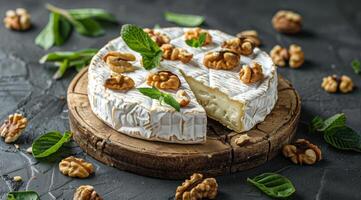 A Creamy Brie Wheel With Walnuts and Mint on a Wooden Board photo