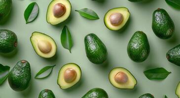 Freshly Sliced Avocados With Basil Leaves on a Green Background photo