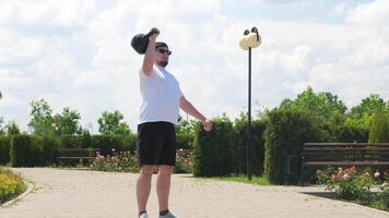 Esportes e lazer. Forte caucasiano homem trabalhando Fora usando kettlebell dentro a parque video