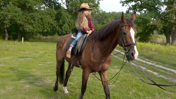 jung blond Cowgirl im Hut Reiten ihr Pferd. schleppend Bewegung. video