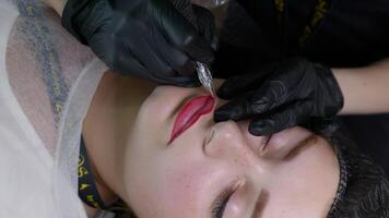 microblading labbro tatuaggio con speciale colorazione pigmento quello corregge labbro colore nel cosmetologia clinica. mano fa permanente trucco labbra procedura l'applicazione pigmento trucco su labbra con tatuaggio macchina video