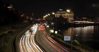 4K time-lapse dense car traffic with bright headlights in the city at night, public transport concept. Kiev district - Podil video