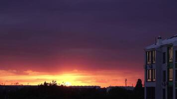 Brightly red cumulus clouds swirl at sunset. 4K Timelapse video