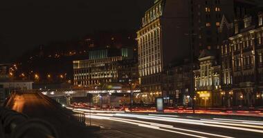 4K time-lapse dense car traffic with bright headlights in the city at night, public transport concept. Kiev district - Podil video