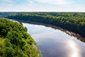 Breathtaking Landscape A Beautiful River Flows Through Charming Air and Lush Trees, Creating a Serene and Picturesque Natural Haven for All to Enjoy photo