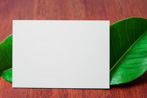 Beautiful Mockup Paper on Wooden Background Combined with Leaves, Creating a Charming and Natural Setting for Creative Designs and Artistic Presentations photo