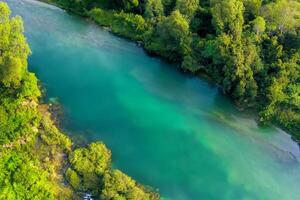 Breathtaking Landscape A Beautiful River Flows Through Charming Air and Lush Trees, Creating a Serene and Picturesque Natural Haven for All to Enjoy photo