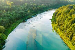 asombroso paisaje un hermosa río fluye mediante encantador aire y lozano árboles, creando un sereno y pintoresco refugio para naturaleza amantes a disfrutar y encontrar tranquilidad en el abrazo de naturaleza foto