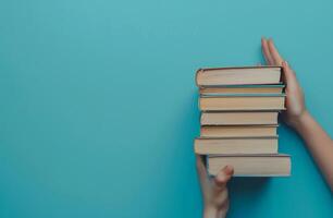 Person Holding a Stack of Books photo