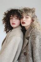Two Women Standing Next to Each Other Wearing Coats photo