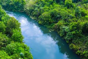 asombroso paisaje un hermosa río fluye mediante encantador aire y lozano árboles, creando un sereno y pintoresco refugio para naturaleza amantes a disfrutar y encontrar tranquilidad en el abrazo de naturaleza foto