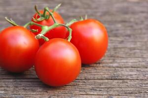 hermosa Fresco tomate en de madera antecedentes un vibrante monitor de de la naturaleza generosidad, mejorando culinario delicias con Rico sabor y saludable bondad foto