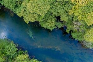 Breathtaking Landscape A Beautiful River Flows Through Charming Air and Lush Trees, Creating a Serene and Picturesque Natural Haven for All to Enjoy photo