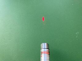 KYIV, UKRAINE - May 8, 2024 Handheld laser pointer shines a beam photo