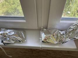 Food foil lies on the windowsill in the house photo