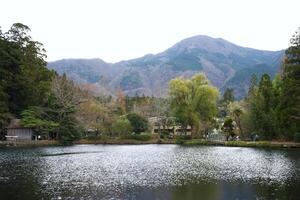 Yufuin, Japan - December 9 2022 - Kinrin Lake with Mount Yufu in Background and sky with clouds photo