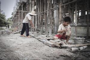 Two poor children are forced to work in construction. Poor children, poverty, Child labor, World Day Against Child Labour concept. photo