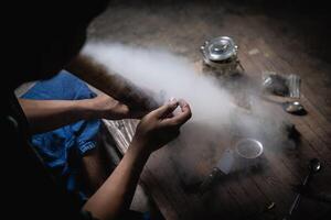 A man prepares marijuana on a cutting board to smoke, person who smokes drugs, drug addict, Drugs addiction and withdrawal symptoms concept. drugsInternational Day against Drug Abuse. photo