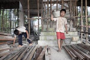 child labor concept. Children working at construction site, Poor children, poverty. photo