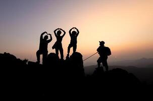 silueta de persona caminantes alpinismo arriba montaña acantilado y uno de ellos dando Ayudar mano. personas éxito, equipo trabajo concepto. foto