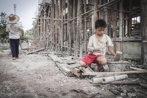 Two poor children are forced to work in construction. Poor children, poverty, Child labor, World Day Against Child Labour concept. photo