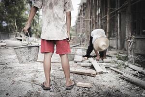 Poor children are forced to work in construction. are forced to work in the construction area. Human rights concepts, stopping child abuse, violence, fear of child labor and human trafficking. photo